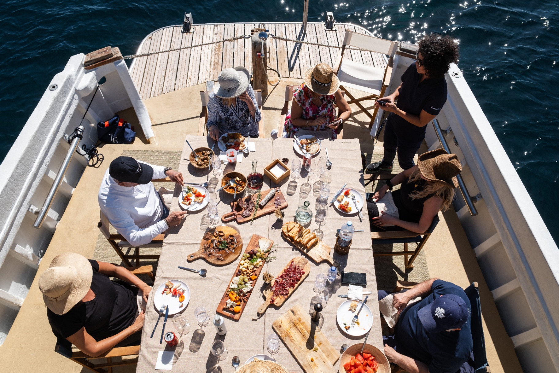 Catering gourmet a bordo con aperitivos y vino en el barco clásico